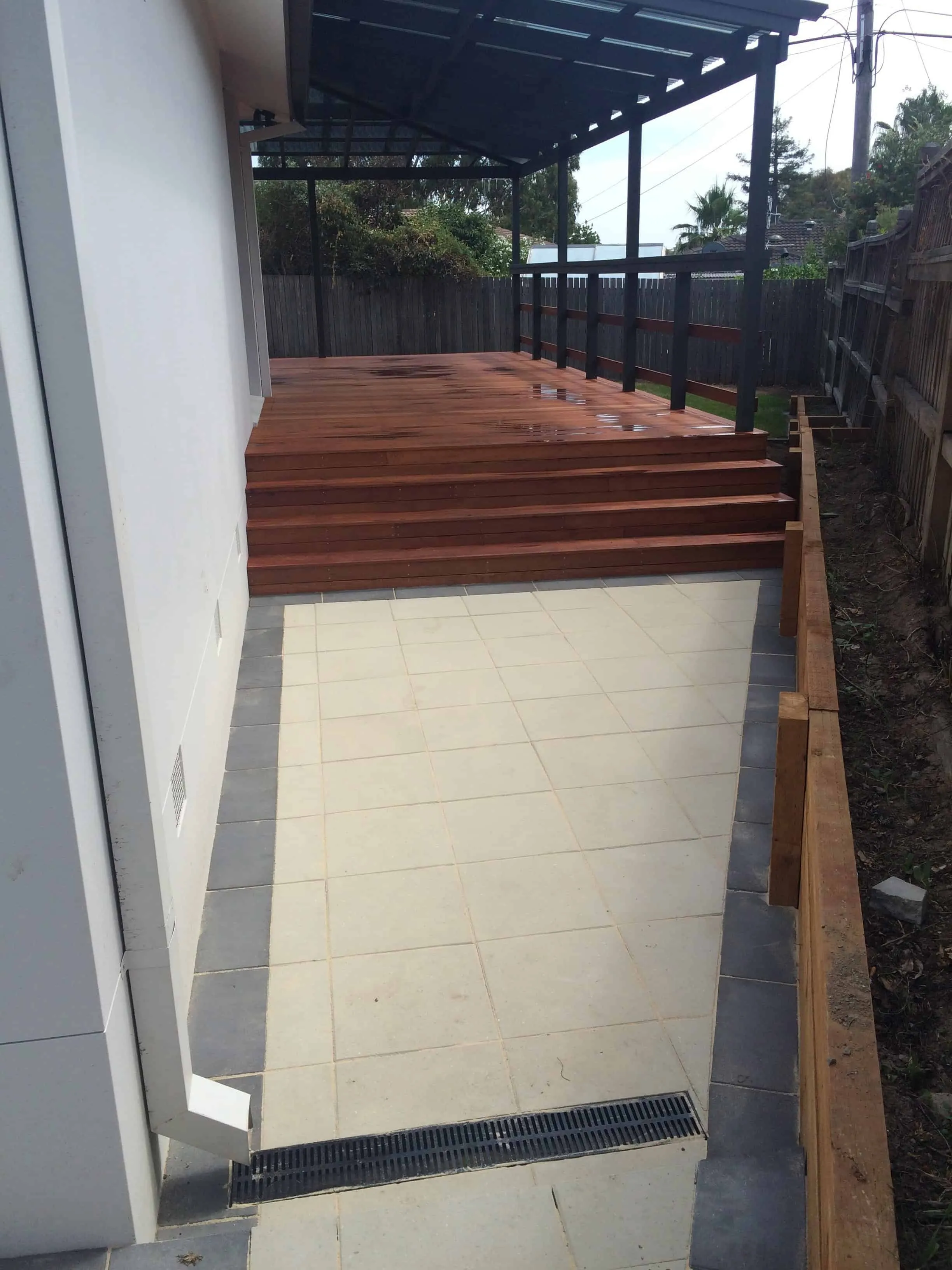 The same backyard finished with a timber deck, pergola and new lawn