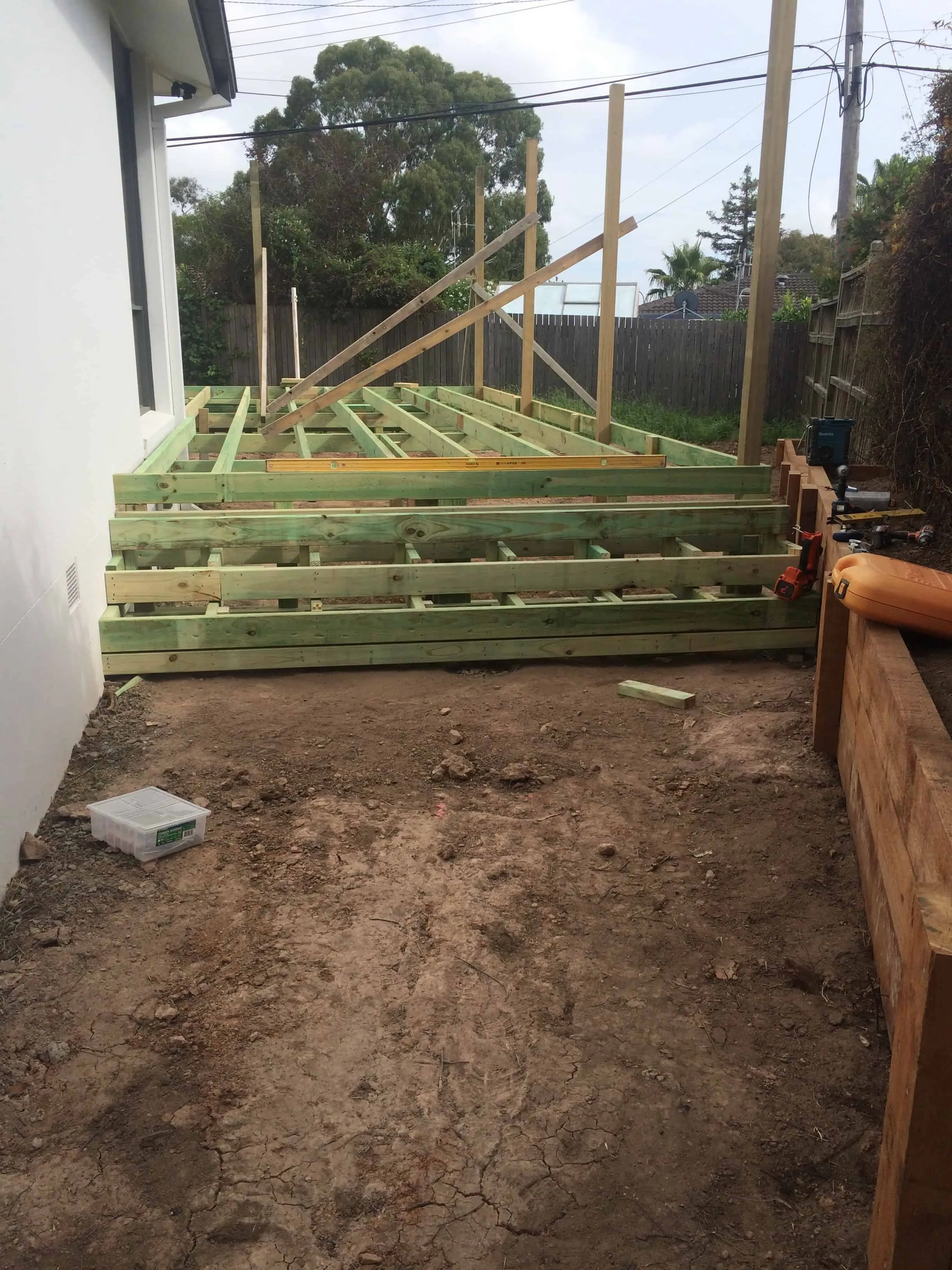 A bare Canberra backyard with dirt and timber deck framing before Dust To Lawn