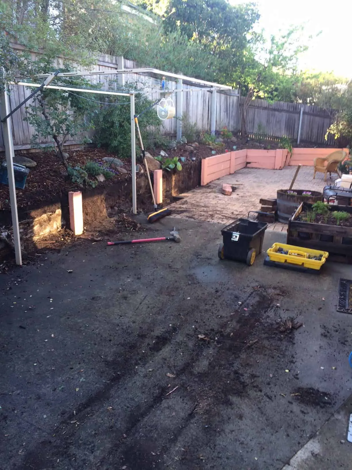A bare dirt yard with an old timber wall before Dust To Lawn